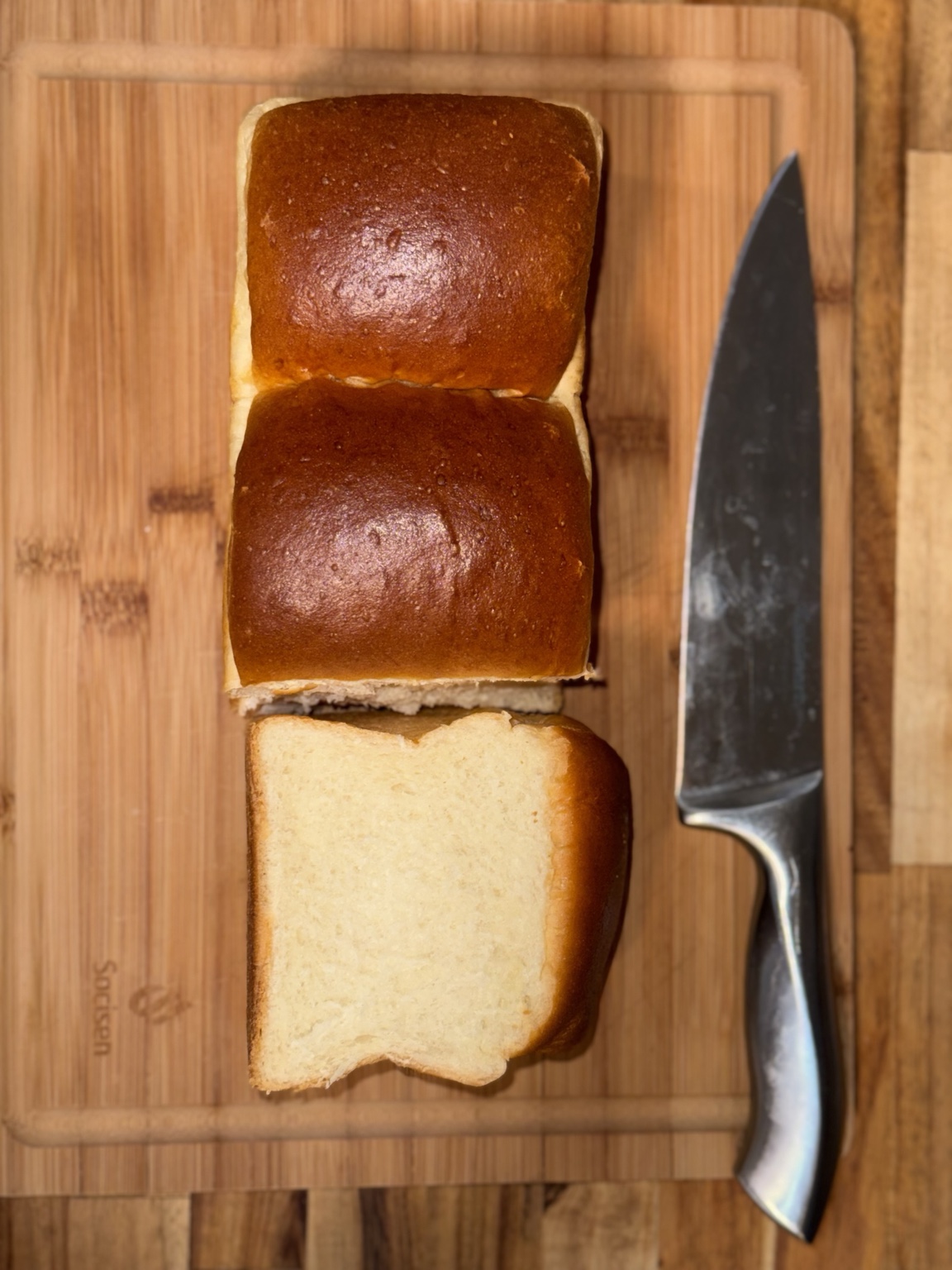 Freshly baked Japanese milkbread beside a chef's knife